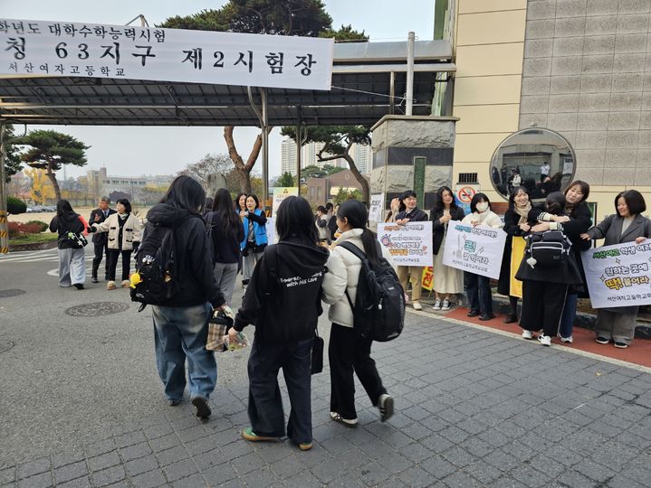 [서산=뉴시스] 김덕진 기자 = 13일 서산여고에서 수능을 치르는 수험생들이 학부모회 등의 응원을 받으며 학교로 들어가고 있다. 2025.11.13. spark@newsis.com *재판매 및 DB 금지
