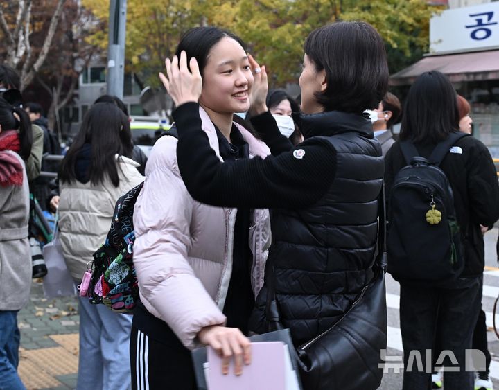 [서울=뉴시스] 사진공동취재단 = 2026학년도 대학수학능력시험(수능)일인 13일 오전 서울 광진구 광남고등학교에서 한 수험생이 교문 앞에서 어머니의 응원을 받고 있다. 2025.11.13. photo@newsis.com