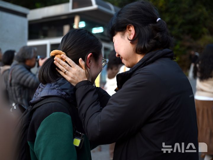 [광주=뉴시스] 이현행 기자 = 사진은 2026학년도 대학수학능력시험이 종료된 지난해 11월13일 오후 광주 남구 봉선동 동아여고(26지구 제32시험장)에서 학부모가 수능을 마친 딸을 쓰다듬고 있는 모습. 2025.11.13. lhh@newsis.com