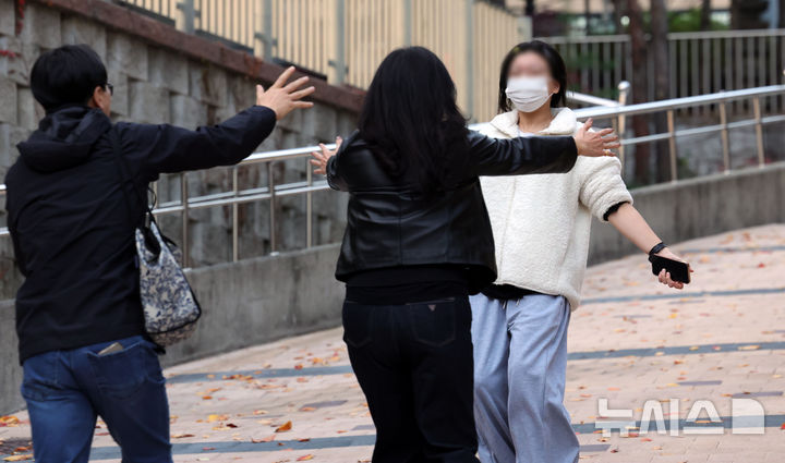 [서울=뉴시스] 홍효식 기자 = 2026학년도 대학수학능력시험을 마친 수험생이 13일 오후 서울 마포구 홍익대학교사범대학부속여자고등학교에서 가족들과 포옹하고 있다. 2025.11.13. yesphoto@newsis.com