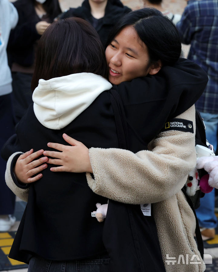 [서울=뉴시스] 홍효식 기자 = 2026학년도 대학수학능력시험을 마친 수험생이 13일 오후 서울 마포구 홍익대학교사범대학부속여자고등학교에서 가족과 포옹하고 있다. 2025.11.13. yesphoto@newsis.com