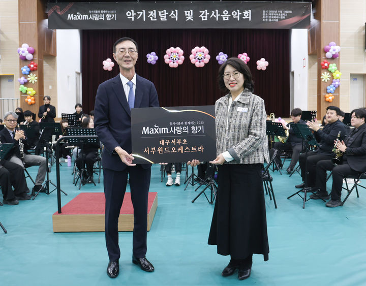 [서울=뉴시스] 지난 13일 대구서부초등학교에서 열린 '제18회 맥심 사랑의 향기' 행사에서 최상인 동서식품 홍보상무(왼쪽)와 이보경 대구서부초등학교 교장이 기념촬영을 하고 있다.(사진=동서식품 제공) *재판매 및 DB 금지