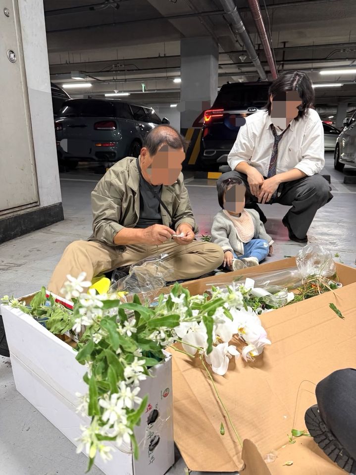 [뉴시스] 딸의 결혼식 부케가 시들까 걱정한 70대 아버지가 예식장 지하 주차장에서 직접 부케를 만들고 있다. (사진=스레드 캡처) *재판매 및 DB 금지
