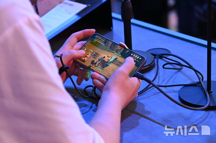 [부산=뉴시스] 윤정민 기자 = 14일 오전 부산 벡스코에서 진행 중인 '지스타 2025' 크래프톤 부스에서 한 참관객이 '팰월드 모바일'을 시연하고 있다. 2025.11.15. alpaca@newsis.com