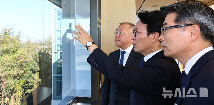 [화성=뉴시스] 박주성 기자 = 김민석 국무총리(가운데)와 정의선 현대차그룹 회장(왼쪽), 송호성 기아차 사장이 14일 경기도 화성시 우정읍 기아오토랜드 화성 내 화성대에서 미래차 산업전략 대회 전 공장 전경을 보며 이야기를 나누고 있다. 2025.11.14. park7691@newsis.com