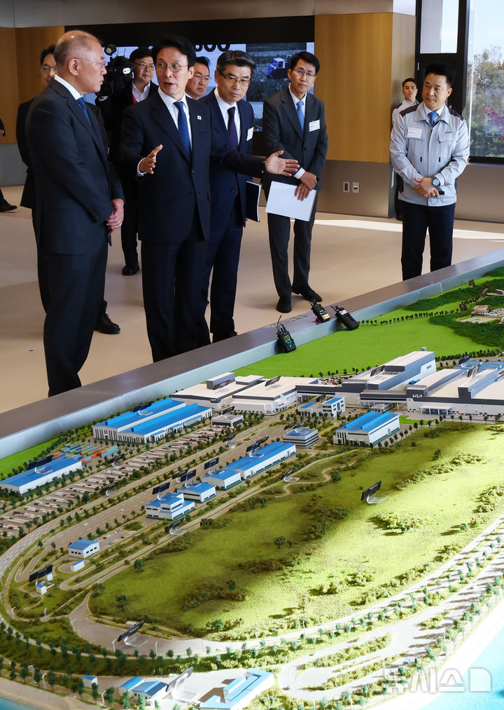 [화성=뉴시스] 박주성 기자 = 김민석 국무총리와 정의선 현대차그룹 회장이 14일 경기도 화성시 우정읍 기아오토랜드 화성 내 화성대에서 미래차 산업전략 대화 전 공장 전경 모형을 보며 이야기를 나누고 있다. 2025.11.14. park7691@newsis.com