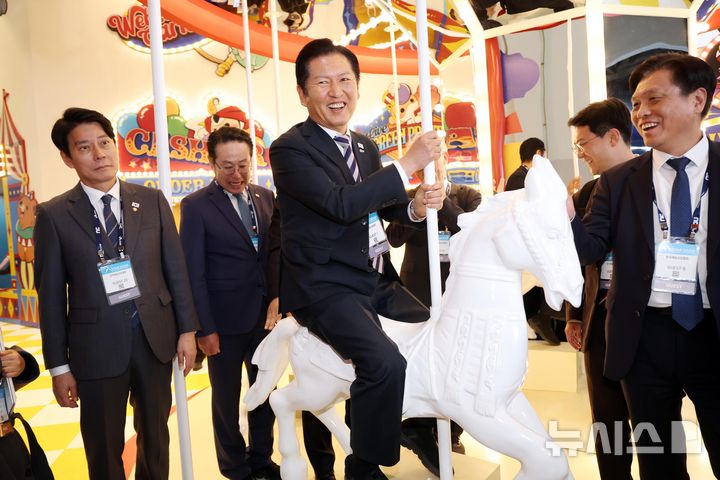  [부산=뉴시스] 하경민 기자 = 정청래 더불어민주당 대표가 14일 부산 해운대구 벡스코에서 열린 글로벌 게임전시회 '지스타 2025' 행사장을 방문, 게임업체 부스에 마련된 회전목마 포토존에 오르고 있다. 2025.11.14. yulnetphoto@newsis.com