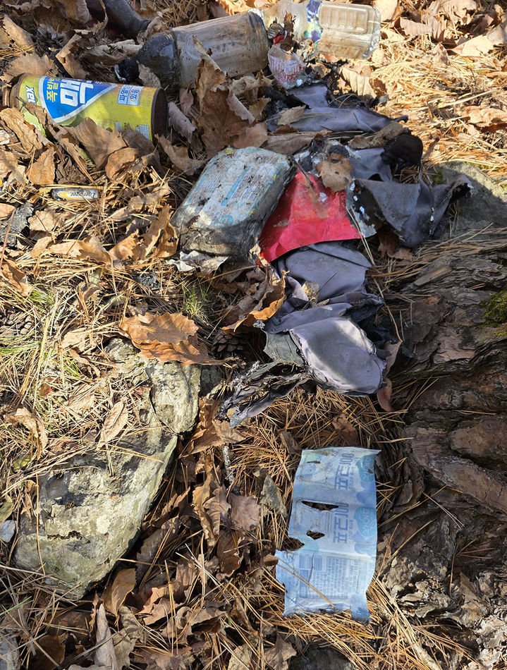 지난 15일 태백시 문곡소도동 함백산 기슭 '목없는 시신'이 발견된 현장에서 수습된 생수병과 콜라병, 부탄가스통, 불에 태운 옷가지 등 모습.(사진=뉴시스) *재판매 및 DB 금지