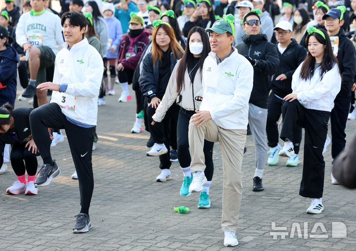 [서울=뉴시스] 이영환 기자 = 오세훈 서울시장과 배우 이재윤 및 시민들이 16일 오전 서울 마포구 상암월드컵공원 평화광장에서 열린 2025 서울 쉬엄쉬엄 런에 참석해 몸풀기를 하고 있다. 2025.11.16. 20hwan@newsis.com