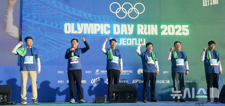 [전주=뉴시스] 김얼 기자 = 김관영(왼쪽 두번째) 전북특별자치도지사를 비롯한 관계자들이 16일 전북 전주시 전주월드컵경기장에서 열린 '2025 올림픽 데이런 인 전주'에 참석해 구호를 외치고 있다. 2025.11.16. pmkeul@newsis.com