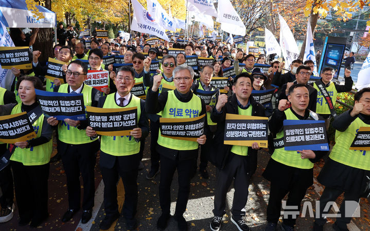 [서울=뉴시스] 이영환 기자 = 김택우 대한의사협회 회장 및 참석자들이 16일 오후 서울 여의도 국회 앞에서 열린 국민건강수호 및 의료악법저지를 위한 전국의사 대표자 궐기대회에서 구호를 외치고 있다. 2025.11.16. 20hwan@newsis.com