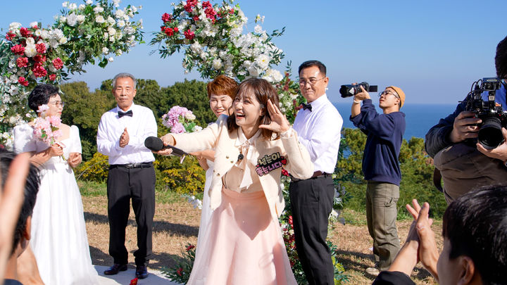 [거제=뉴시스] 신정철 기자= 거제시는 지난 15일, 동백 원시림의 아름다움으로 유명한 일운면 지심도에서 ‘2025년 자연과 함께하는 웨딩·휴양섬’의 세 번째 프로그램으로 황혼 부부 3쌍을 초청해 감동적인 리마인드 웨딩과 기념 촬영 행사를 개최했다.사진은 리포터로 나선 트로트 가수 정다경의 축하 공연 모습.(사진=거제시 제공).2025.11.17. photo@newsis.com *재판매 및 DB 금지