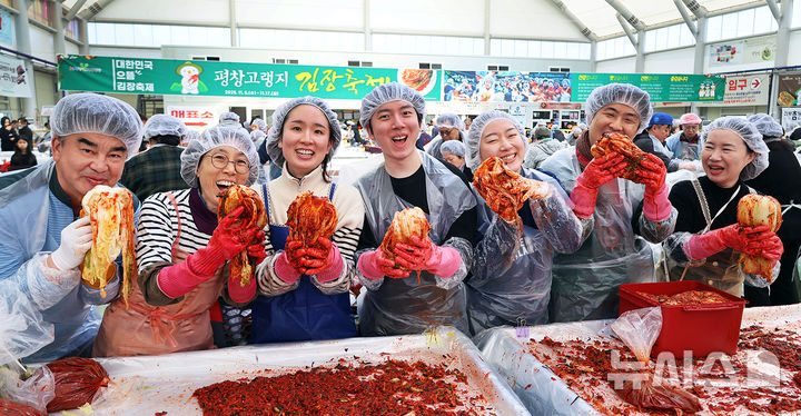 [평창=뉴시스] 17일 '평창고랭지김장축제'가 열리고 있는 강원 평창군 진부면민체육공원 체험장에 축제장을 찾은 방문객들이 즐거운 표정으로 김장을 담그고 있다. (사진=평창군 제공) 2025.11.17. photo@newsis.com
