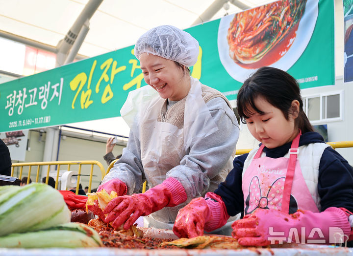 [평창=뉴시스] 17일 '평창고랭지김장축제'가 열리고 있는 강원 평창군 진부면민체육공원 체험장에 축제장을 찾은 방문객들이 즐거운 표정으로 김장을 담그고 있다. (사진=평창군 제공) 2025.11.17. photo@newsis.com