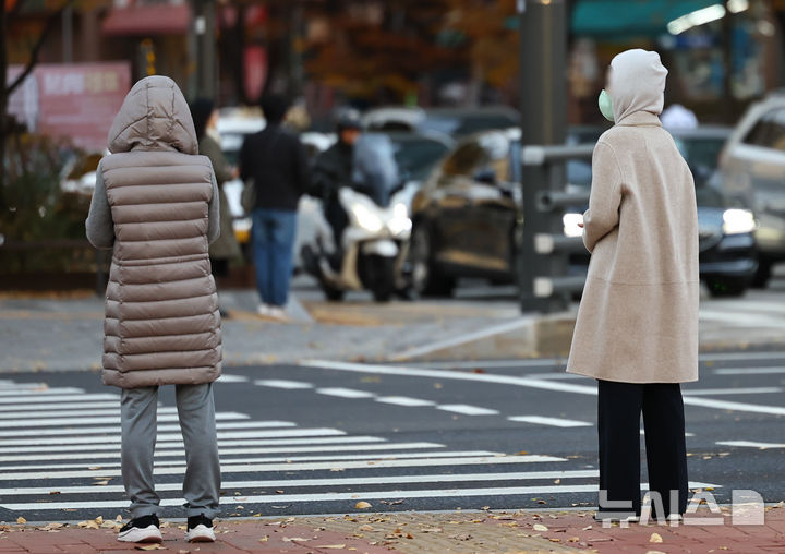 [서울=뉴시스] 최진석 기자 = 밤사이 초겨울 추위가 찾아온 17일 오전 서울 용산 한 도로에서 시민들이 바람을 피하며 신호를 기다리고 있다. 2025.11.17. myjs@newsis.com