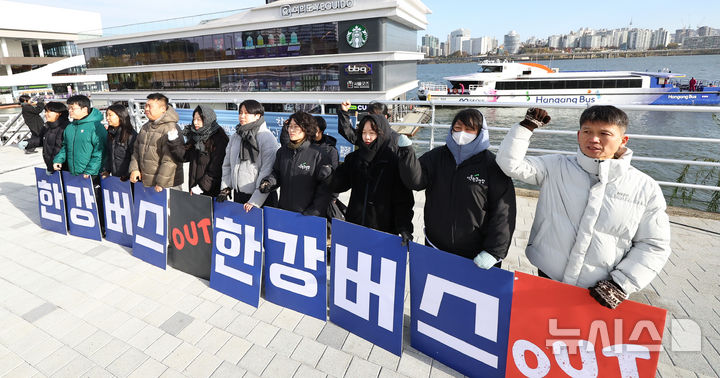 [서울=뉴시스] 최진석 기자 = 17일 서울 여의도 한강버스 선착장 앞에서 서울환경연합 운동가들이 강바닥 좌초 사고에도 운항 강행하는 서울시 규탄 한강버스 사업 전면 재검토 촉구 기자회견하는 뒤로 한강버스가 지나가고 있다. 20225.11.17. myjs@newsis.com