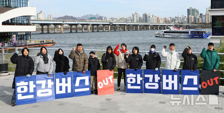 [서울=뉴시스] 최진석 기자 = 17일 서울 여의도 한강버스 선착장 앞에서 서울환경연합 운동가들이 강바닥 좌초 사고에도 운항 강행하는 서울시 규탄 한강버스 사업 전면 재검토 촉구 기자회견하는 뒤로 한강버스가 지나가고 있다. 20225.11.17. myjs@newsis.com