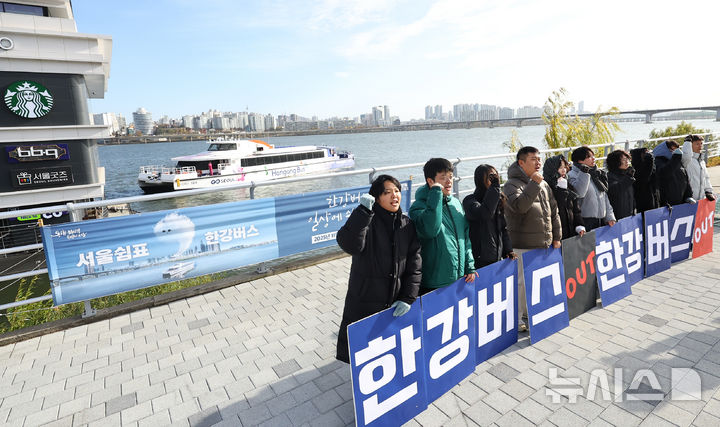 [서울=뉴시스] 최진석 기자 = 17일 서울 여의도 한강버스 선착장 앞에서 서울환경연합 운동가들이 강바닥 좌초 사고에도 운항 강행하는 서울시 규탄 한강버스 사업 전면 재검토 촉구 기자회견하는 뒤로 한강버스가 지나가고 있다. 20225.11.17. myjs@newsis.com