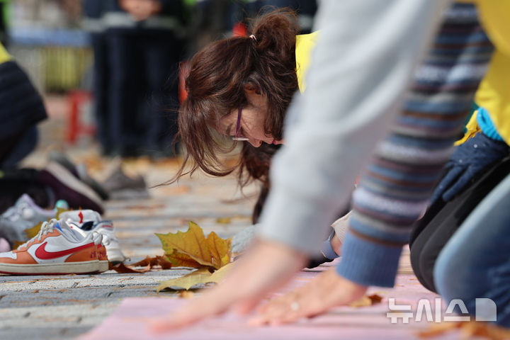 [서울=뉴시스] 권창회 기자 =마트산업노동조합 조합원들이 지난 17일 오전 서울 용산구 대통령실 인근에서 기업회생 258일, 홈플러스 사태해결 정부개입 촉구 258배를 하고 있다. 2025.11.17. kch0523@newsis.com
