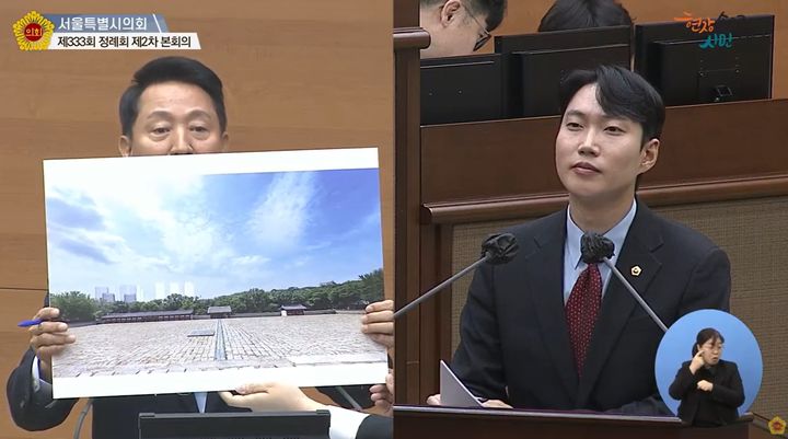 [서울=뉴시스] 종묘 경관 그림 공개한 오세훈 서울시장과 시정질문 중인 김규남 서울시의원. 2025.11.18. (사진=서울시의회 유튜브 화면 갈무리) *재판매 및 DB 금지