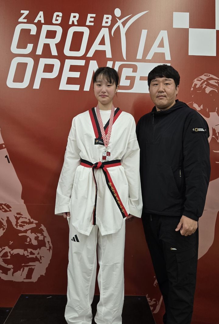 [고성(경남)=뉴시스] 신정철 기자= 경남 고성군 소가야중학교 3학년 서현 선수가 지난 15일 크로아티아 자그레브에서 개최된 ‘제29회 자그레브 크로아티아 오픈(WT-G1) 태권도대회’에서 은메달을 목에 걸었다.사진은 최창윤 감독(고성군 유소년태권도단)과 서현 선수가 기념사진을 촬영하고 있는 모습.(사진=고성군 제공).2025.11.18. photo@newsis.com *재판매 및 DB 금지