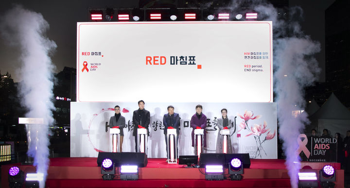 [서울=뉴시스] 레드 마침표 캠페인 응원 세리머니에 참석한 관계자들이 무대에 올라 연대의 메시지를 전달하고 있다. 왼쪽부터 공공소통연구소 이종혁 소장, 국립중앙의료원 감염내과 진범식 교수, KNP+ 손석수 대표, 신나는센터 김승환 상임이사, 길리어드 코리아 최재연 대표이사 (사진=레드 마침표 협의체 제공) 2025.11.18. photo@newsis.com *재판매 및 DB 금지