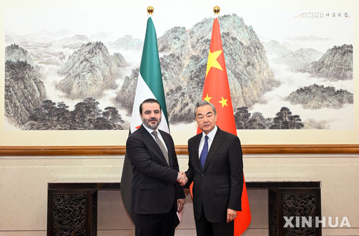 [베이징=AP/뉴시스] 아스아드 알-샤이바니 시리아 외교장관(왼쪽)이 17일 중국 베이징에서 왕이 중국공산당 정치국 위원 겸 외교부장과 악수하고 있다. 두 장관은 이날 회담을 갖고, 테러 대응 협력 및 양국 관계 정상화에 대해 논의했다. 2025.11.18