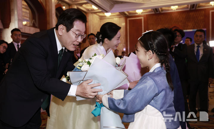 [아부다비=뉴시스] 최동준 기자 = 남아공 G20 정상회의 참석 차 아랍에미리트(UAE)를 국빈 방문한 이재명 대통령과 김혜경 여사가 17일(현지 시간) 아부다비의 한 호텔에서 열린 동포 만찬 간담회에서 화동에게 꽃다발을 받고 있다. 2025.11.18. photocdj@newsis.com