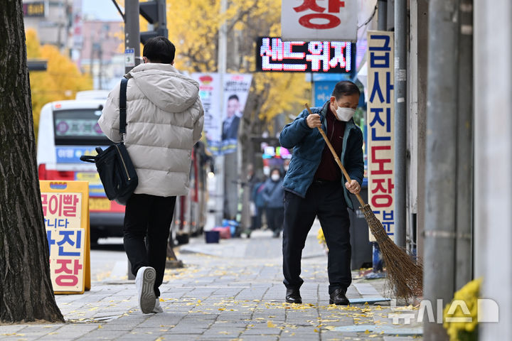 [광주=뉴시스] 이영주 기자 = 광주·전남 최저기온이 영하 4.8도를 기록한 18일 오전 광주 북구 오치동 한 거리에서 시민이 낙엽을 쓸고 있다. 2025.11.18. leeyj2578@newsis.com