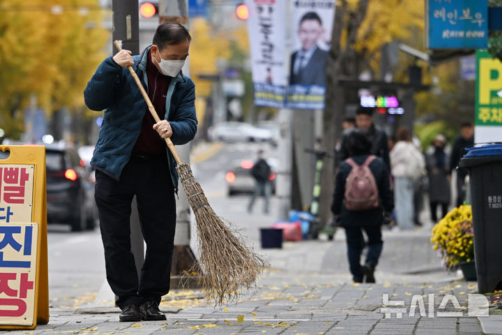 [광주=뉴시스] 이영주 기자 = 광주·전남 최저기온이 영하 4.8도를 기록한 18일 오전 광주 북구 오치동 한 거리에서 시민이 낙엽을 쓸고 있다. 2025.11.18. leeyj2578@newsis.com