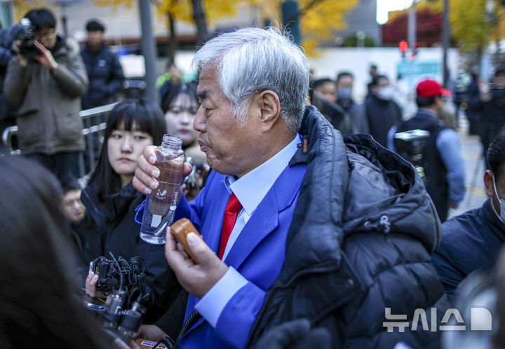 [서울=뉴시스] 정병혁 기자 = 특수건조물침입·특수공무집행방해 교사 등 혐의를 받는 전광훈 사랑제일교회 목사가 18일 서울 종로구 서울경찰청으로 피의자 신분 조사를 받기 위해 출석하며 입장을 밝히며 물을 마시고 있다. 2025.11.18. jhope@newsis.com