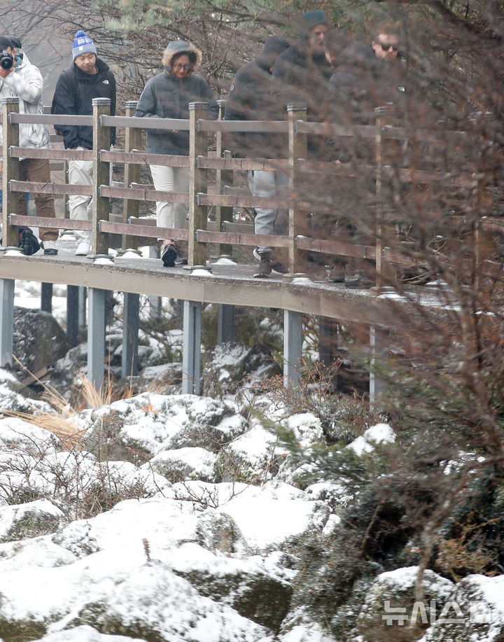 [제주=뉴시스] 우장호 기자 = 올 가을 들어 가장 추운 날씨를 보인 18일 오전 외국인 관광객들이 첫 눈이 쌓인 제주 한라산 1100고지 습지를 감상하고 있다. 2025.11.18. woo1223@newsis.com