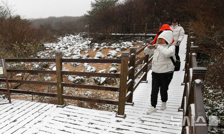 [제주=뉴시스] 우장호 기자 = 올 가을 들어 가장 추운 날씨를 보인 18일 오전 외국인 관광객들이 첫 눈이 쌓인 제주 한라산 1100고지 습지를 감상하고 있다. 2025.11.18. woo1223@newsis.com