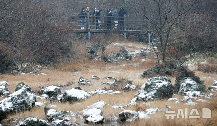 [제주=뉴시스] 우장호 기자 = 올 가을 들어 가장 추운 날씨를 보인 18일 오전 외국인 관광객들이 첫 눈이 쌓인 제주 한라산 1100고지 습지를 감상하고 있다. 2025.11.18. woo1223@newsis.com