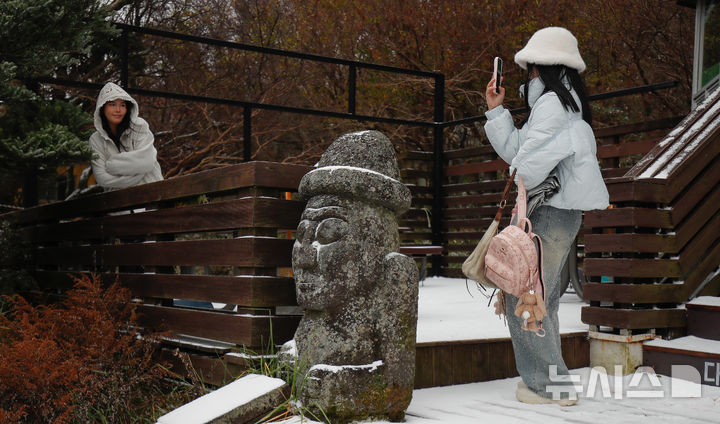 [제주=뉴시스] 우장호 기자 = 올 가을 들어 가장 추운 날씨를 보인 18일 오전 외국인 관광객들이 첫 눈이 쌓인 제주 한라산 1100고지 휴게소 앞에서 기념사진을 찍고 있다. 2025.11.18. woo1223@newsis.com