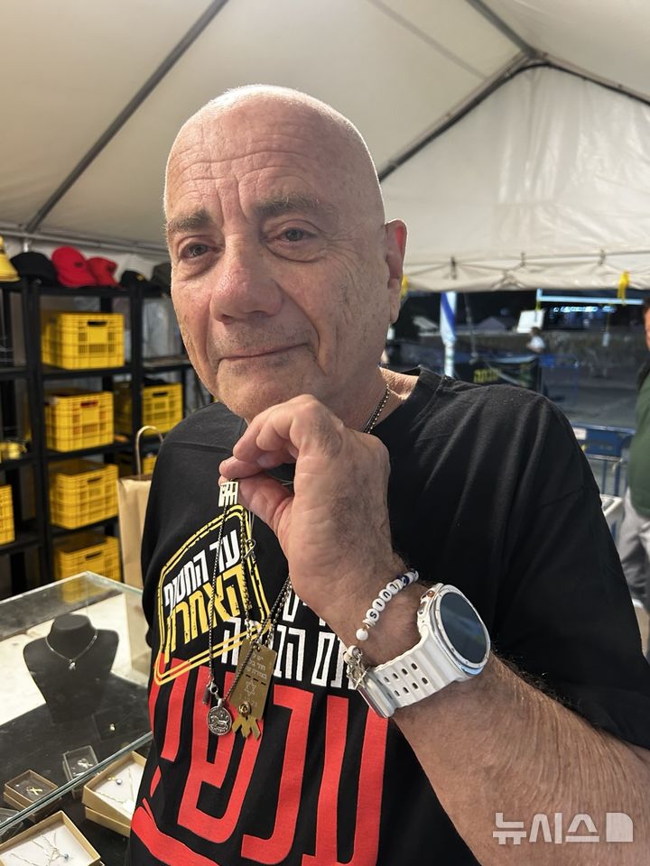 [이스라엘 텔아비브=뉴시스] 최명수 기자 = 이스라엘 텔아비브 인질광장에 설치된 천막 안에서 하마스에 끌려갔다가 구출된 루이스 하르(72)씨가 지난 9일 자신이 억류된 동안 희망을 잃지 않았다며 희망(Hope)을 상징하는 목걸이를 보여주고 있다. 2025.11.09 apollon@newsis.com