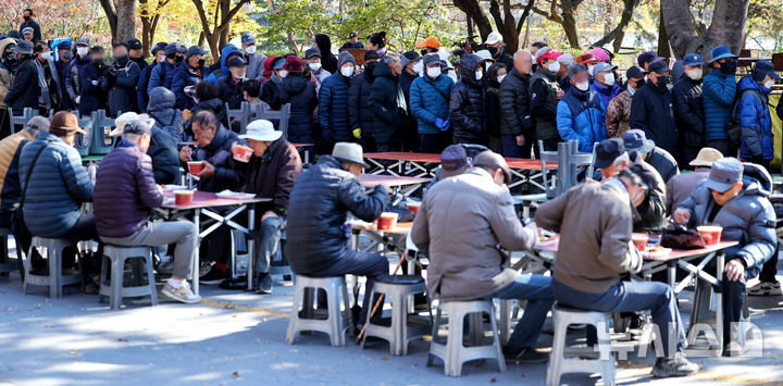 [대구=뉴시스] 이무열 기자 = 대구 달서구 두류공원 사랑해밥차 무료 급식소를 찾은 어르신들이 점심 배식을 받기 위해 줄을 서고 있다. 2025.11.18. lmy@newsis.com
