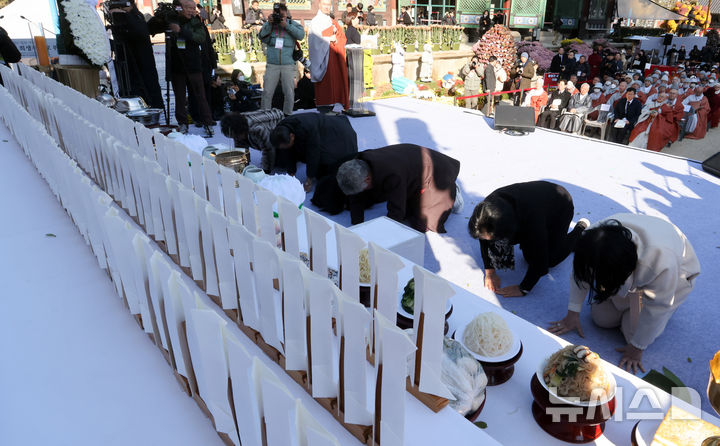 [서울=뉴시스] 청사사진기자단 = 김민석 국무총리가 18일 오후 서울 종로구 조계사에서 열린 산재사망 희생자 추모 위령재에서 유가족들이 헌향·헌다를 마치고 큰절을 하고 있다. 2025.11.18. photo@newsis.com