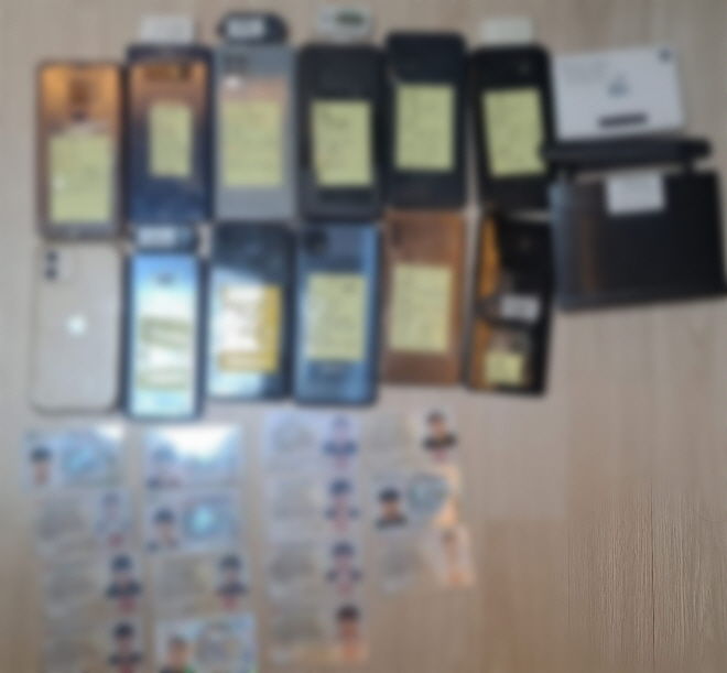 [부산=뉴시스] 허위 투자 리딩 사기로 245억원을 가로챈 조직이 범행에 사용한 타인 명의 휴대전화와 신분증. (사진=부산경찰청 제공) 2025.11.19. photo@newsis.com *재판매 및 DB 금지