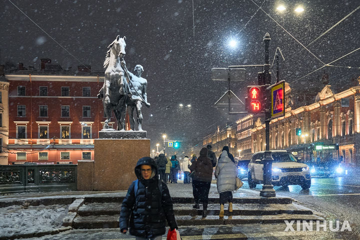 [상트페테르부르크=신화/뉴시스] 18일(현지 시간) 러시아 상트페테르부르크에서 시민들이 눈 내리는 밤거리를 걷고 있다. 2025.11.19.