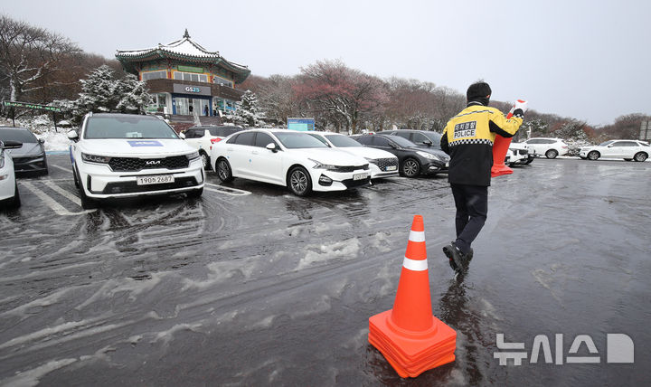 [제주=뉴시스] 우장호 기자 = 추운 날씨를 보인 19일 오전 제주 한라산 1100고지 휴게소 주차장에서 자치경찰이 차량 혼잡을 미연에 방지하기 위해 라바콘을 설치하고 있다. 2025.11.19. woo1223@newsis.com