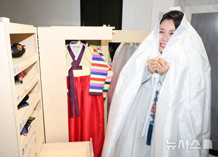 [아부다비=뉴시스] 최동준 기자 = 김혜경 여사가 19일(현지 시간) 아부다비 주UAE한국문화원에서 열린 할랄 K-푸드 홍보행사에서 쓰개치마를 착용해 보고 있다. 2025.11.19. photocdj@newsis.com