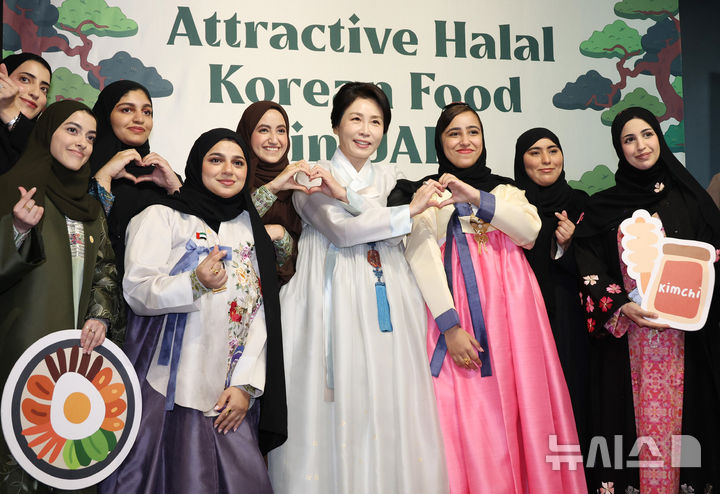 [아부다비=뉴시스] 최동준 기자 = 김혜경 여사가 19일(현지 시간) 아부다비 주UAE한국문화원에서 열린 할랄 K-푸드 홍보행사에서 참석자들과 기념촬영을 하고 있다. 2025.11.19. photocdj@newsis.com