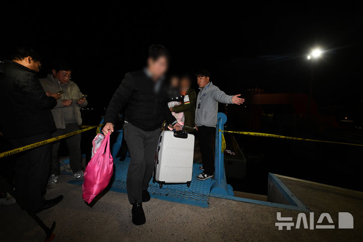 [목포=뉴시스] 이영주 기자 = 19일 오후 전남 목포시 해경부두에서 좌초됐던 퀸제누비아2호 승객들이 무사 구조돼 부두로 이동하고 있다. 2025.11.19. leeyj2578@newsis.com