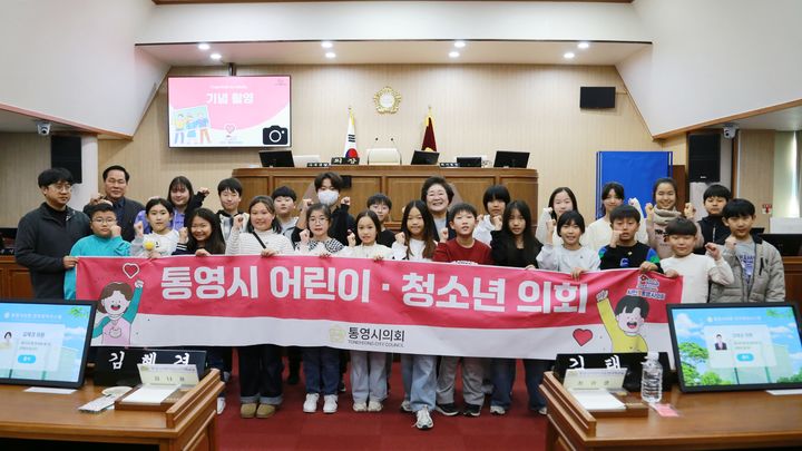 [통영=뉴시스] 신정철 기자= 경남 통영시의회는 19일, 관내 학생들이 지방의회의 기능과 역할을 체험학습 형식으로 친근하고 알기 쉽게 배울 수 있는 지방의회 체험 활동인 통영시의회 제5회 어린이·청소년의회교실을 개회했다.사진은 원평초등학교 학생 24명이 참석한 가운데 본회의장에서 모의의회를 개회하고 기념사진을 촬영하고 있다.(사진=통영시의회 제공).2025.11.19. photo@newsis.com *재판매 및 DB 금지