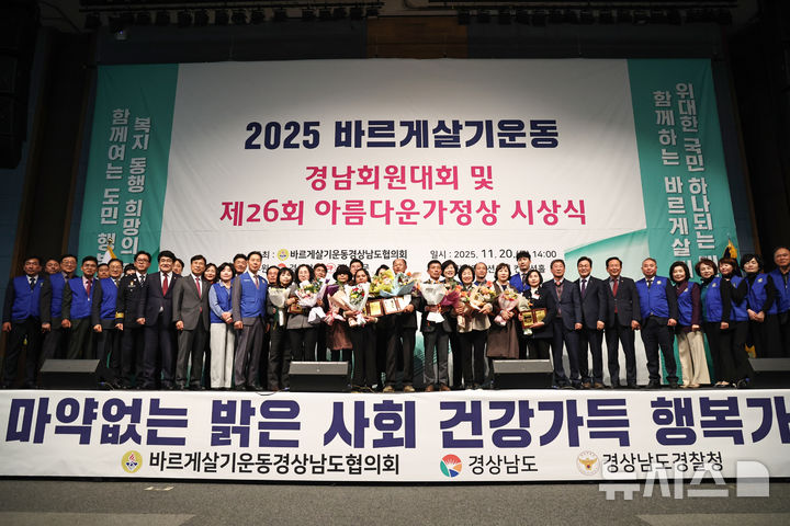 [창원=뉴시스]20일 오후 창원컨벤션센터에서 열린 바르게살기운동 경상남도협의회 주최 '2025 바르게살기운동 경남회원대회 및 제26회 아름다운 가정상 시상식'에서 아름다운 가정상 수상 가족들이 주요 인사들과 기념촬영하고 있다.(사진=경남도 제공) 2025.11.20. photo@newsis.com