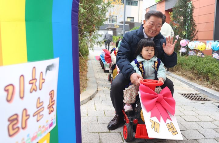 [광명=뉴시스]박승원 광명시장이 20일 광명호반써밋그랜드에비뉴 1단지에서 열린 ‘시립호반써밋어린이집’ 개원식에 참석해 원아와 함께 행사 프로그램인 코끼리 기차를 타고 기념촬영을 하고 있다.(사진=광명시 제공)2025.11.20.photo@newsis.com *재판매 및 DB 금지