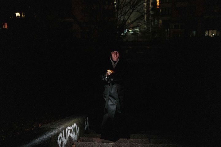 [키이우=AP/뉴시스] 지난달 20일(현지 시간) 러시아군의 에너지 시설 공격으로 정전된 우크라이나 키이우에서 한 여성이 휴대전화 불빛에 의지해 거리를 걷고 있다. 2025.12.07.