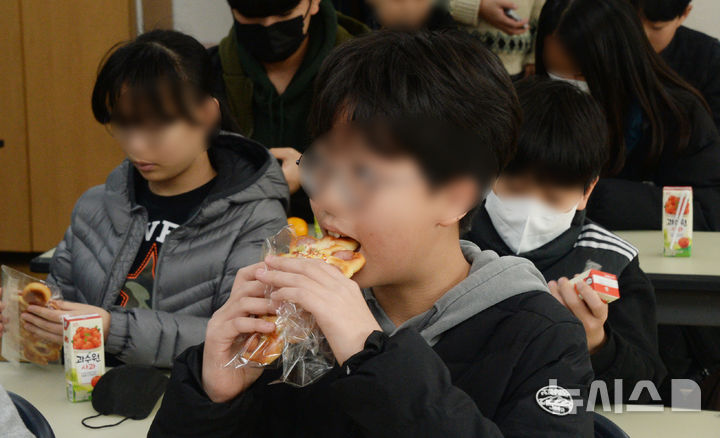 [전주=뉴시스] 김얼 기자 = 급식, 돌봄 등을 담당하는 전국학교비정규직 연대회의가 릴레이 총파업에 돌입한 21일 전북 전주시 완산구의 한 초등학교에서 학생들이 대체 급식인 빵과 음료를 먹고 있다. 2025.11.21. pmkeul@newsis.com