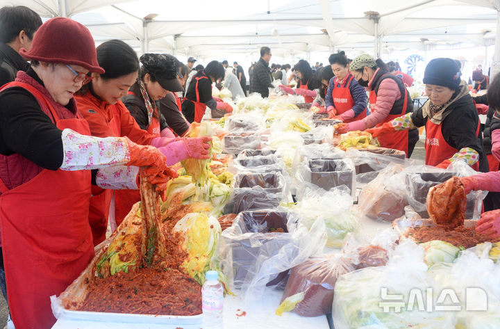 [전주=뉴시스] 김얼 기자 = '제7회 2025 전주김장문화축제'가 열린 22일 전북 전주시 전주월드컵경기장을 찾은 시민들이 김장을 담그고 있다. 2025.11.22. pmkeul@newsis.com
